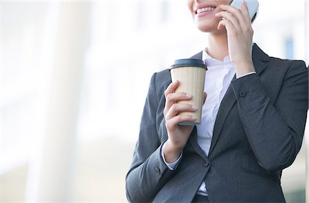 simsearch:693-06403498,k - Midsection of businesswoman using cell phone while holding disposable cup outdoors Stock Photo - Premium Royalty-Free, Code: 693-08126998