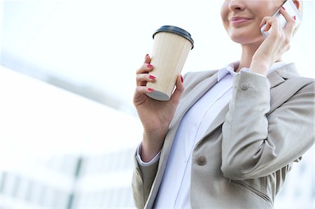 simsearch:693-06403498,k - Midsection of businesswoman using cell phone while holding disposable cup outdoors Stock Photo - Premium Royalty-Free, Code: 693-08127009