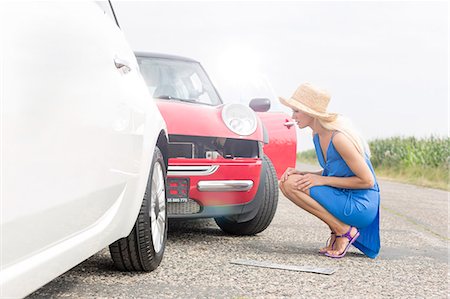 simsearch:693-08127065,k - Full-length side view of tensed woman looking at damaged cars on road Photographie de stock - Premium Libres de Droits, Code: 693-08127077