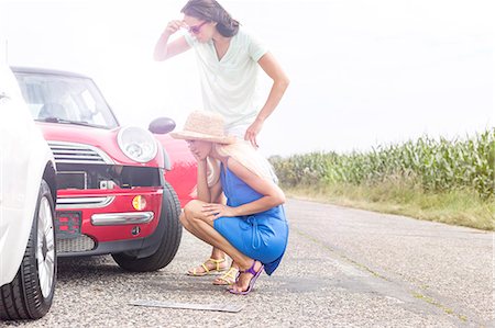 Tensed women looking at damaged cars on road against clear sky Stock Photo - Premium Royalty-Free, Code: 693-08127078