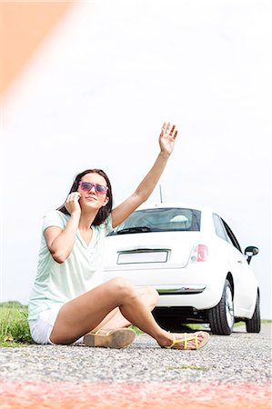 Frustrated woman hitchhiking while using cell phone by broken down car Foto de stock - Sin royalties Premium, Código: 693-08127081