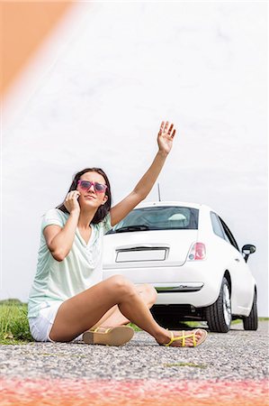 summer car trouble - Frustrated woman hitchhiking while using cell phone on country road by broken down car Stock Photo - Premium Royalty-Free, Code: 693-08127135