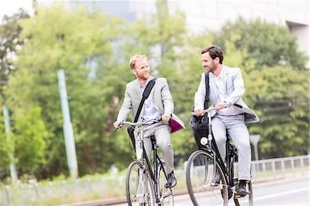 Businessmen talking while cycling outdoors Stock Photo - Premium Royalty-Free, Code: 693-08127164