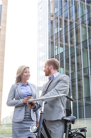 simsearch:693-08127175,k - Smiling business couple talking outside office building Fotografie stock - Premium Royalty-Free, Codice: 693-08127172