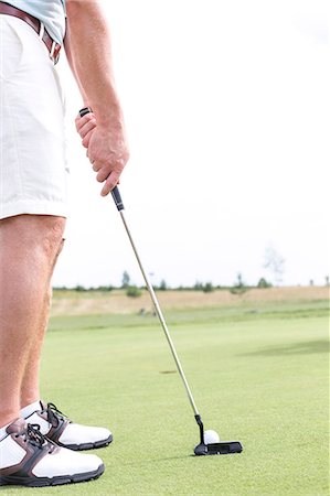 simsearch:693-08127270,k - Low section of mid-adult man playing golf against clear sky Foto de stock - Sin royalties Premium, Código: 693-08127208