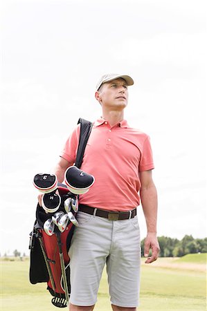 Thoughtful middle-aged man looking away while carrying golf bag against clear sky Stock Photo - Premium Royalty-Free, Code: 693-08127215