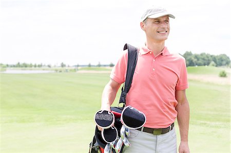 Happy middle-aged man looking away while carrying golf bag Foto de stock - Sin royalties Premium, Código: 693-08127218