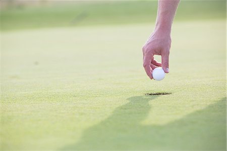 simsearch:693-08127270,k - Cropped image of hand holding golf ball over cup Foto de stock - Sin royalties Premium, Código: 693-08127212