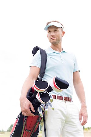 european male - Low angle view of thoughtful mid-adult man carrying golf club bag against clear sky Stock Photo - Premium Royalty-Free, Code: 693-08127221