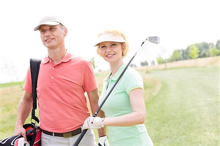 simsearch:693-06668077,k - Smiling male and female friends standing at golf course Fotografie stock - Premium Royalty-Free, Codice: 693-08127243