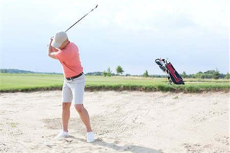 swinging - Man swinging at golf course against sky Foto de stock - Sin royalties Premium, Código: 693-08127268