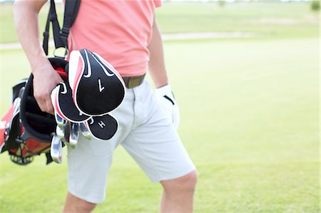 Midsection of man carrying golf club bag at course Photographie de stock - Premium Libres de Droits, Code: 693-08127262