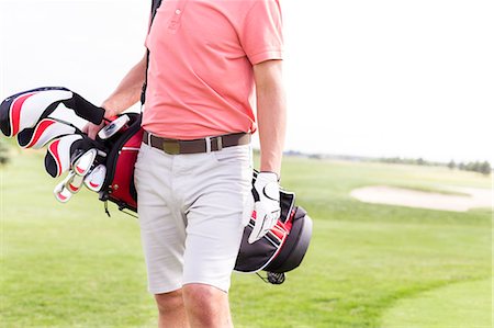 simsearch:649-08422474,k - Midsection of man with golf club bag standing at course Stock Photo - Premium Royalty-Free, Code: 693-08127263