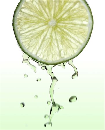 Fresh lime slice with juice drops Stock Photo - Premium Royalty-Free, Code: 693-08127437