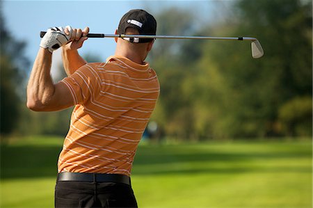 recreation golfing - Young man swinging golf club, rear view Stock Photo - Premium Royalty-Free, Code: 693-08127460