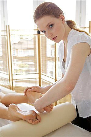 female foot massage - Young woman receiving foot massage from masseuse Photographie de stock - Premium Libres de Droits, Code: 693-08127480