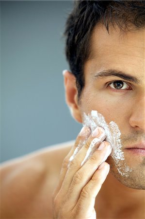 espuma de afeitar - Close-up of young man applying shaving cream Foto de stock - Sin royalties Premium, Código: 693-08127545