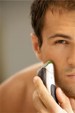 simsearch:693-06019176,k - Reflection of young man in mirror shaving with electric shaver Stock Photo - Premium Royalty-Free, Code: 693-08127547