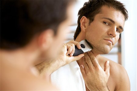 simsearch:693-06019176,k - Reflection of young man in mirror shaving with electric shaver Stock Photo - Premium Royalty-Free, Code: 693-08127542