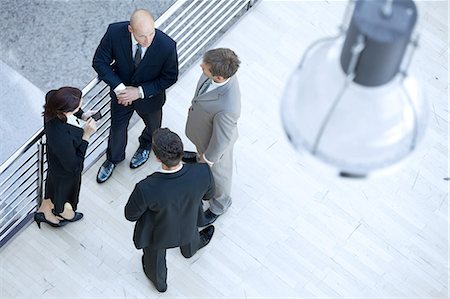 Businessmen and businesswoman standing together by railing Stock Photo - Premium Royalty-Free, Code: 693-08127596