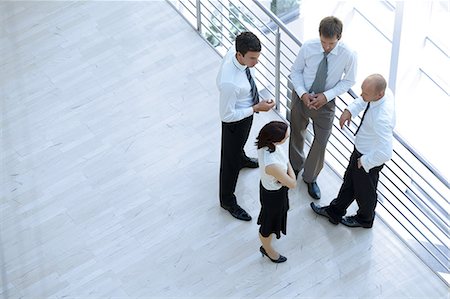 simsearch:693-03301185,k - Businessmen and woman standing together by railing and conversing Stock Photo - Premium Royalty-Free, Code: 693-08127599