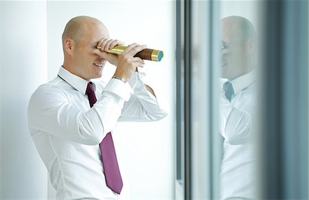 person focusing telescope - caucasian businessman spying using telescope thru office window Stock Photo - Premium Royalty-Free, Code: 693-08127612