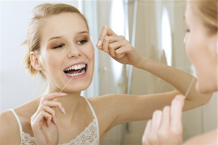 A young woman flossing her teeth Foto de stock - Sin royalties Premium, Código: 693-08127644