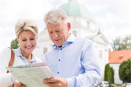 Smiling middle-aged couple reading map outdoors Stock Photo - Premium Royalty-Free, Code: 693-08127679