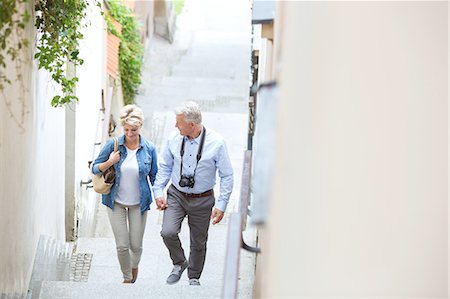 High angle view of middle-aged couple holding hands while climbing steps outdoors Stock Photo - Premium Royalty-Free, Code: 693-08127700