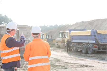 Supervisor explaining plan to colleague at construction site Photographie de stock - Premium Libres de Droits, Code: 693-08127739