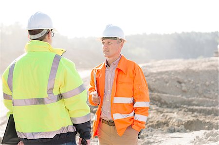 face to face communication in construction site - Supervisors discussing at construction site on sunny day Stock Photo - Premium Royalty-Free, Code: 693-08127767