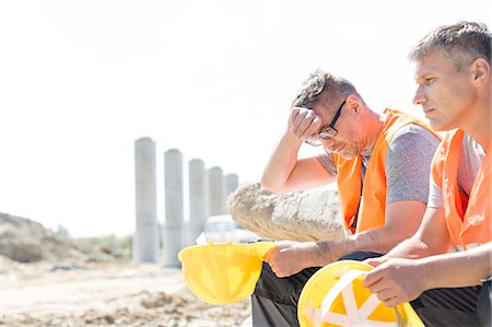 sicherheitsweste - Tired supervisor sitting with colleague at construction site Stockbilder - Premium RF Lizenzfrei, Bildnummer: 693-08127818