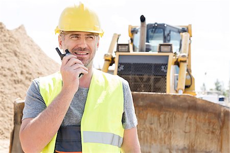 supervisor and worker - Confident supervisor using walkie-talkie at construction site Stock Photo - Premium Royalty-Free, Code: 693-08127829