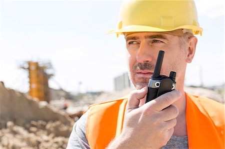 simsearch:693-08127789,k - Confident supervisor using walkie-talkie at construction site Stock Photo - Premium Royalty-Free, Code: 693-08127821