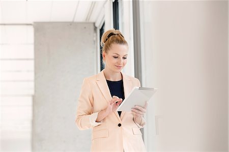 simsearch:693-08769320,k - Young businesswoman using digital tablet in new office Stock Photo - Premium Royalty-Free, Code: 693-08769193