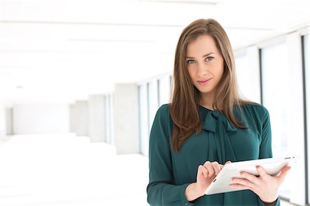 Portrait of confident young businesswoman using digital tablet in office Photographie de stock - Premium Libres de Droits, Code: 693-08769243