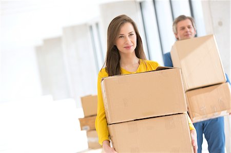 simsearch:693-08769254,k - Young businesswoman with male colleague carrying cardboard boxes in new office Foto de stock - Sin royalties Premium, Código: 693-08769253