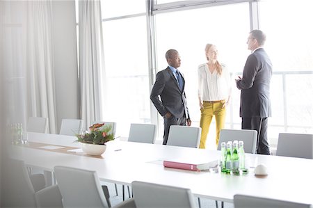 simsearch:693-08769289,k - Business people talking while standing by conference table in office Stock Photo - Premium Royalty-Free, Code: 693-08769279