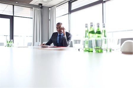 simsearch:693-08769320,k - Young businessman using mobile phone at conference table Stock Photo - Premium Royalty-Free, Code: 693-08769289