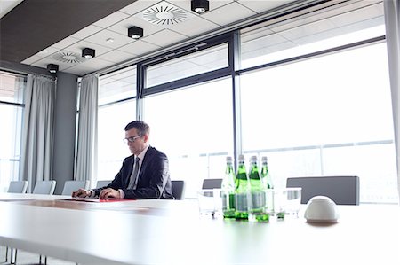 simsearch:693-08769289,k - Mature businessman sitting at conference table in office Stock Photo - Premium Royalty-Free, Code: 693-08769282