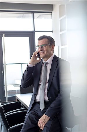 simsearch:693-08769289,k - Mature businessman talking on mobile phone in board room Stock Photo - Premium Royalty-Free, Code: 693-08769298