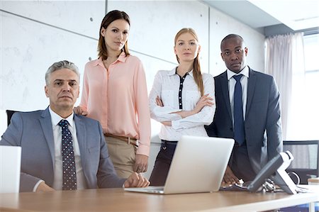 Portrait of confident multi-ethnic business people at desk in office Stock Photo - Premium Royalty-Free, Code: 693-08769339