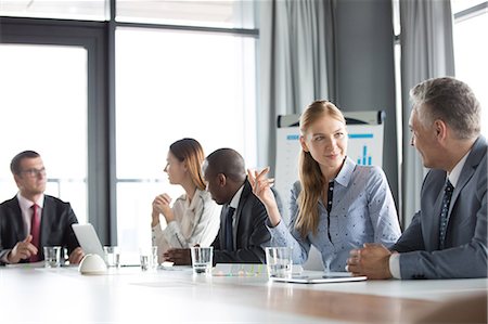 simsearch:693-07913290,k - Young businesswoman discussing with male colleague in board room Foto de stock - Sin royalties Premium, Código: 693-08769362