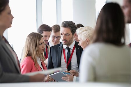 Business people discussing over digital tablet in convention center Stock Photo - Premium Royalty-Free, Code: 693-08769433