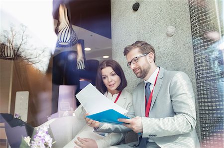 simsearch:693-08769446,k - Business people reading document while sitting in convention center Stock Photo - Premium Royalty-Free, Code: 693-08769448