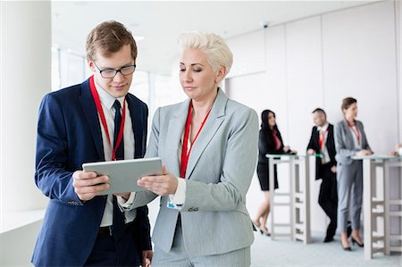 simsearch:693-03301293,k - Business people using digital tablet in convention center Stock Photo - Premium Royalty-Free, Code: 693-08769450