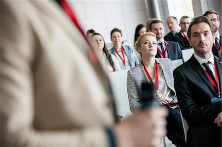 Businessman looking at public speaker in convention center Stock Photo - Premium Royalty-Free, Code: 693-08769453