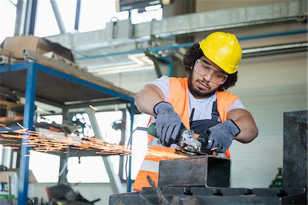 simsearch:6113-07160300,k - Young manual worker in protective workwear cutting metal in industry Stock Photo - Premium Royalty-Free, Code: 693-08769487