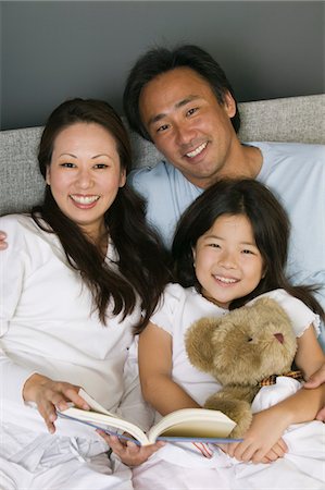 Family Reading in Bed Together, portrait Stock Photo - Premium Royalty-Free, Code: 693-03299401