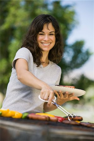 Woman Grilling Food at Park, portrait. Stock Photo - Premium Royalty-Free, Code: 693-03299435